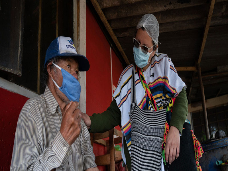 OPS/Karen González Abril Una enfermera revisa a un hombre de origen indígenas en Suba, Bogotá, durante la pandemia de COVID-19