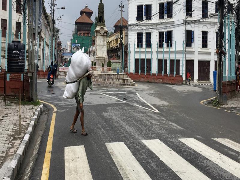 ONU\Vibhu Mishra. Un hombre cargando un bulto en Kathmandu, Nepal