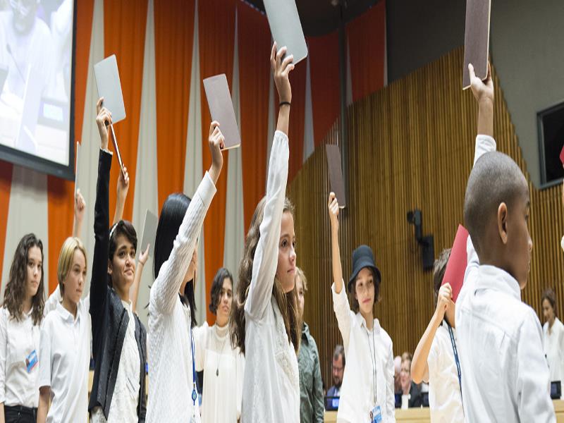 Estos niños y niñas, que asistieron al acto "Financiación para el futuro: educación 2030", defienden su derecho a la educación. Foto ONU/Rick Bajornas